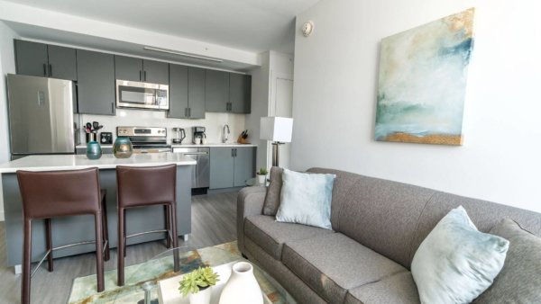 Open plan living are with three seater sofa, breakfast bar and fully equipped kitchen