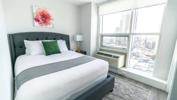 Bedroom featuring freshly made bed and ac unit