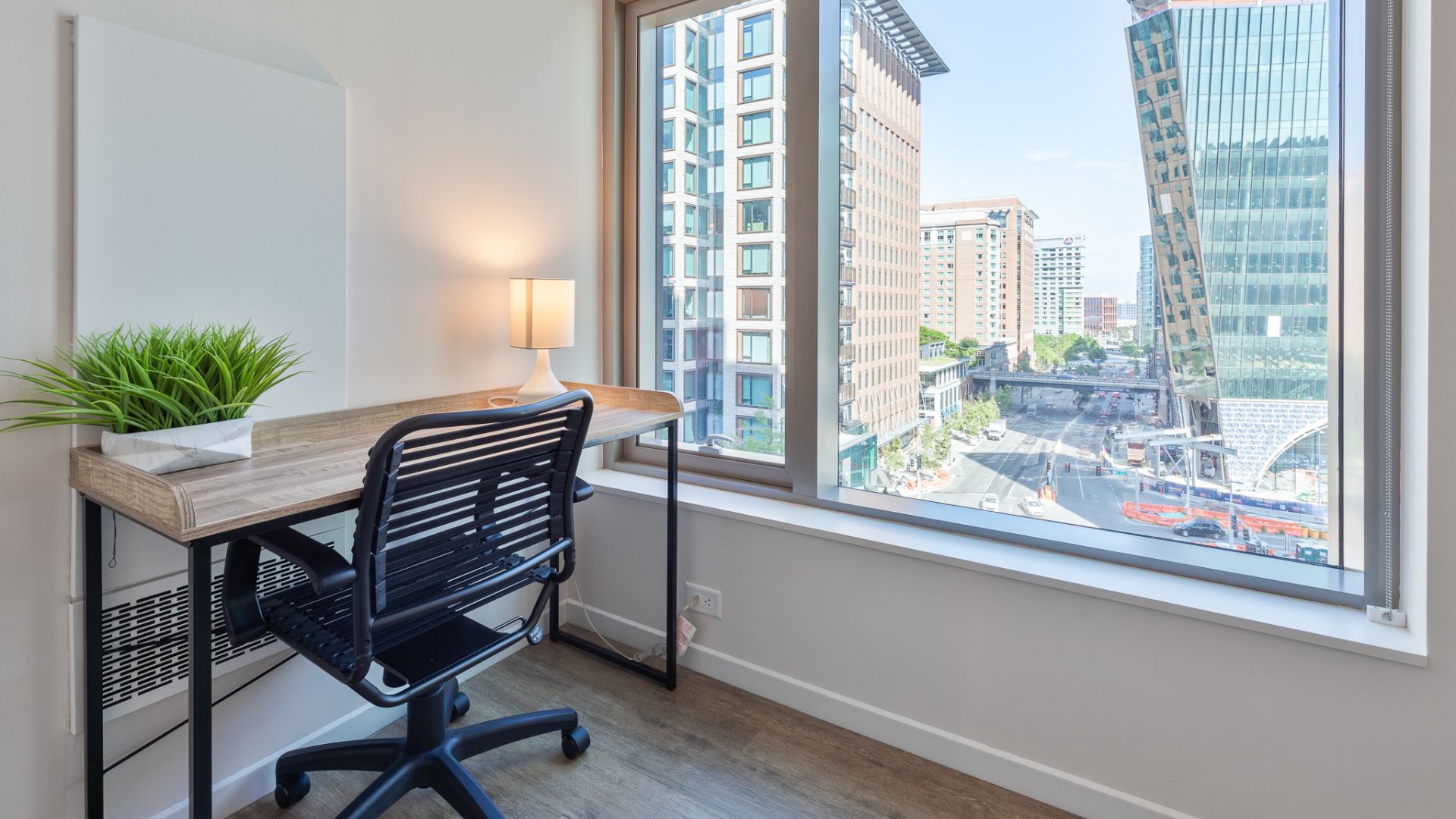 Modern workspace with city view at The Alyx at EchelonSeaport by Compass Furnished Apartments.