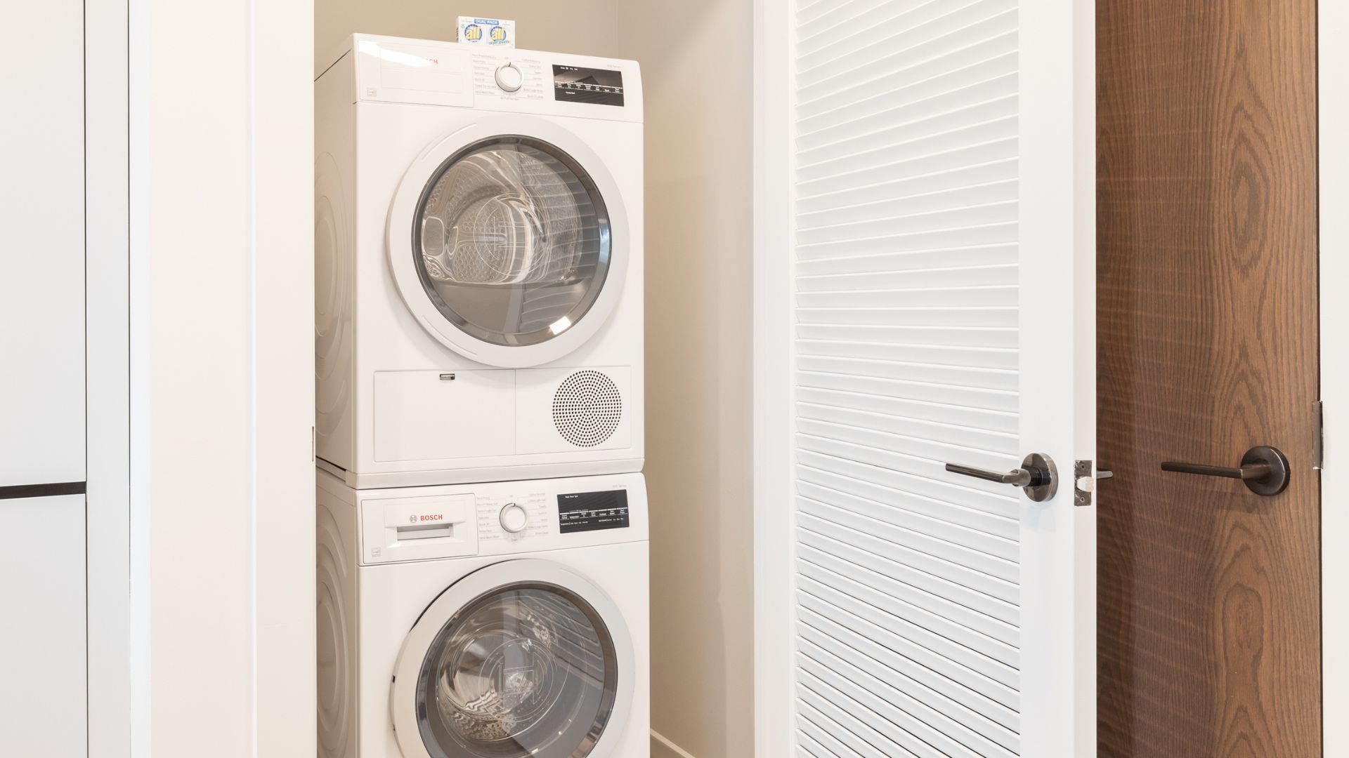 Bosch washer and dryer stacked in-unit at The Alyx at EchelonSeaport by Compass Furnished Apartments.