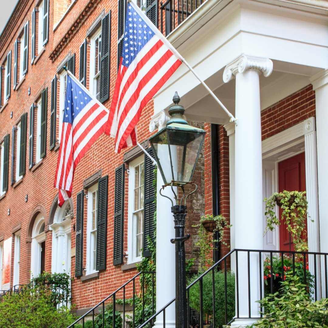 American flags hanging in front of a red brick building
