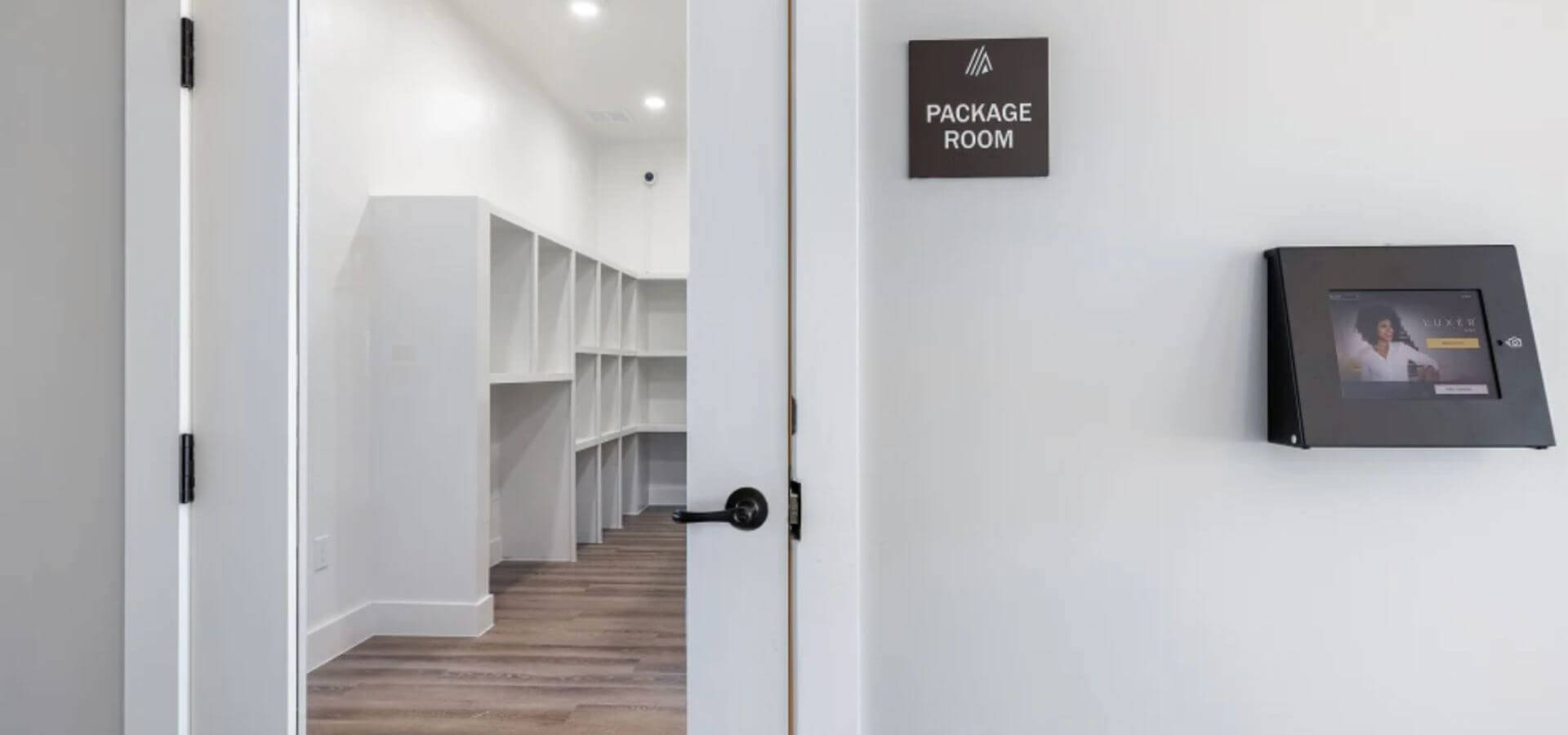 Secure and organized package room at The Avery by Compass Furnished Apartments, featuring labeled storage cubbies and a digital package management system.