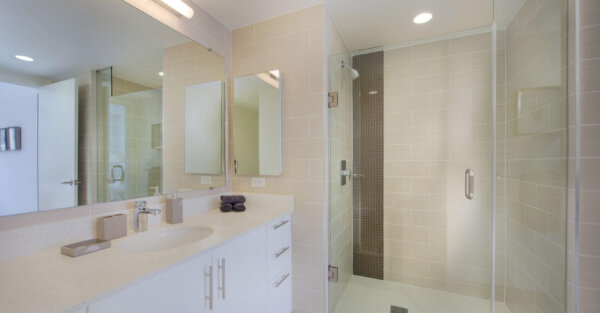 Modern bathroom with walk-in glass shower and sleek vanity at The Apartments at CityCenter by Compass Furnished Apartments.