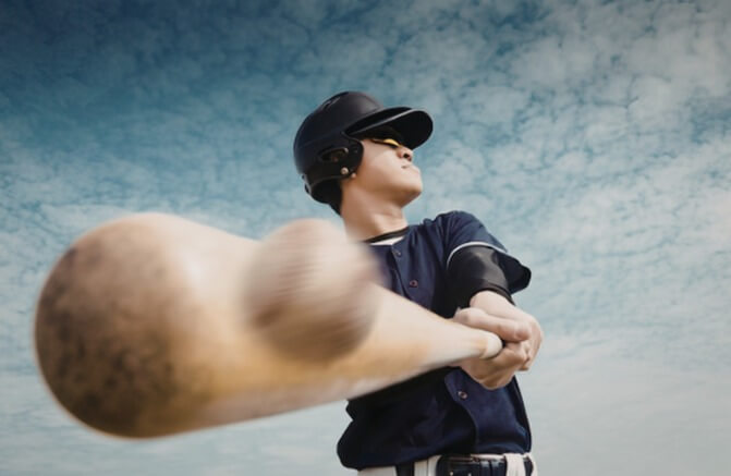 a baseball player swings at a ball
