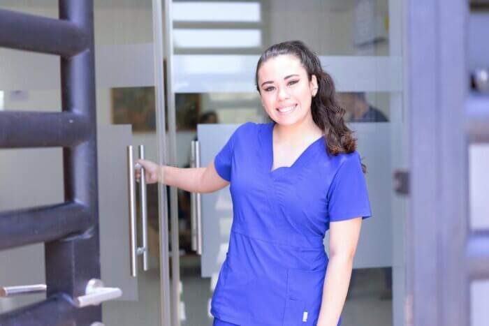 a travel nurse smiles outside of her short term furnished rental for medical professionals