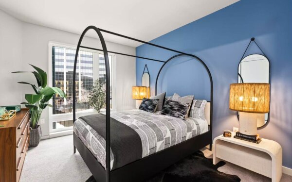 Elegant bedroom at 51 South featuring a contemporary black canopy bed by Compass Furnished Apartments