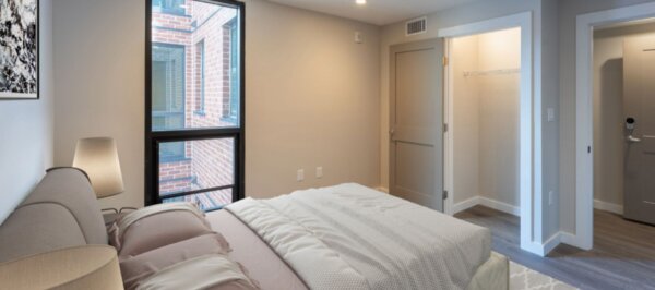 Cozy bedroom at 244 Hanover featuring a large bed, soft lighting, and spacious closet.