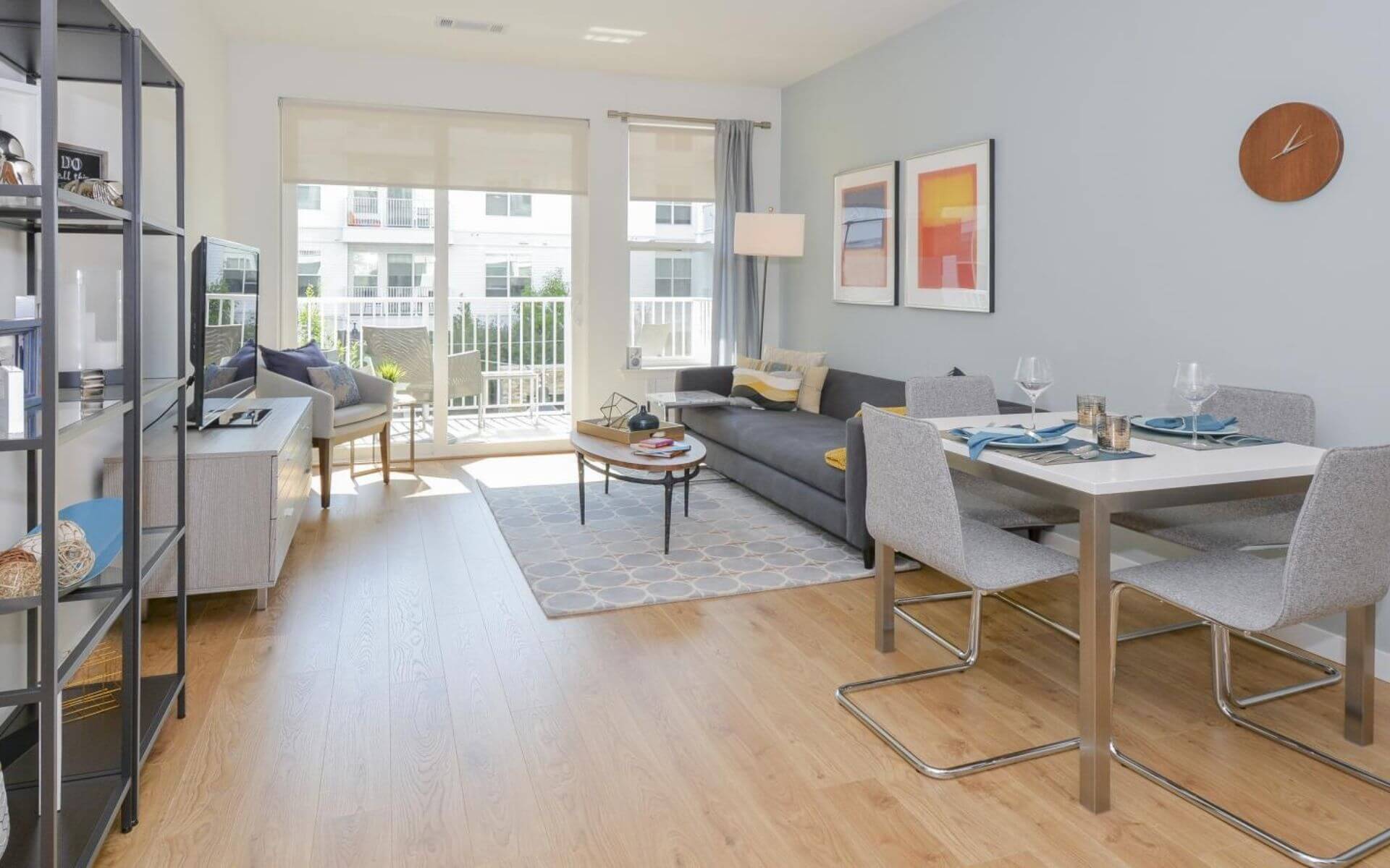 A bright and modern furnished apartment at 75 Tresser, featuring a stylish living and dining area with balcony access—available through Compass Furnished Apartments.