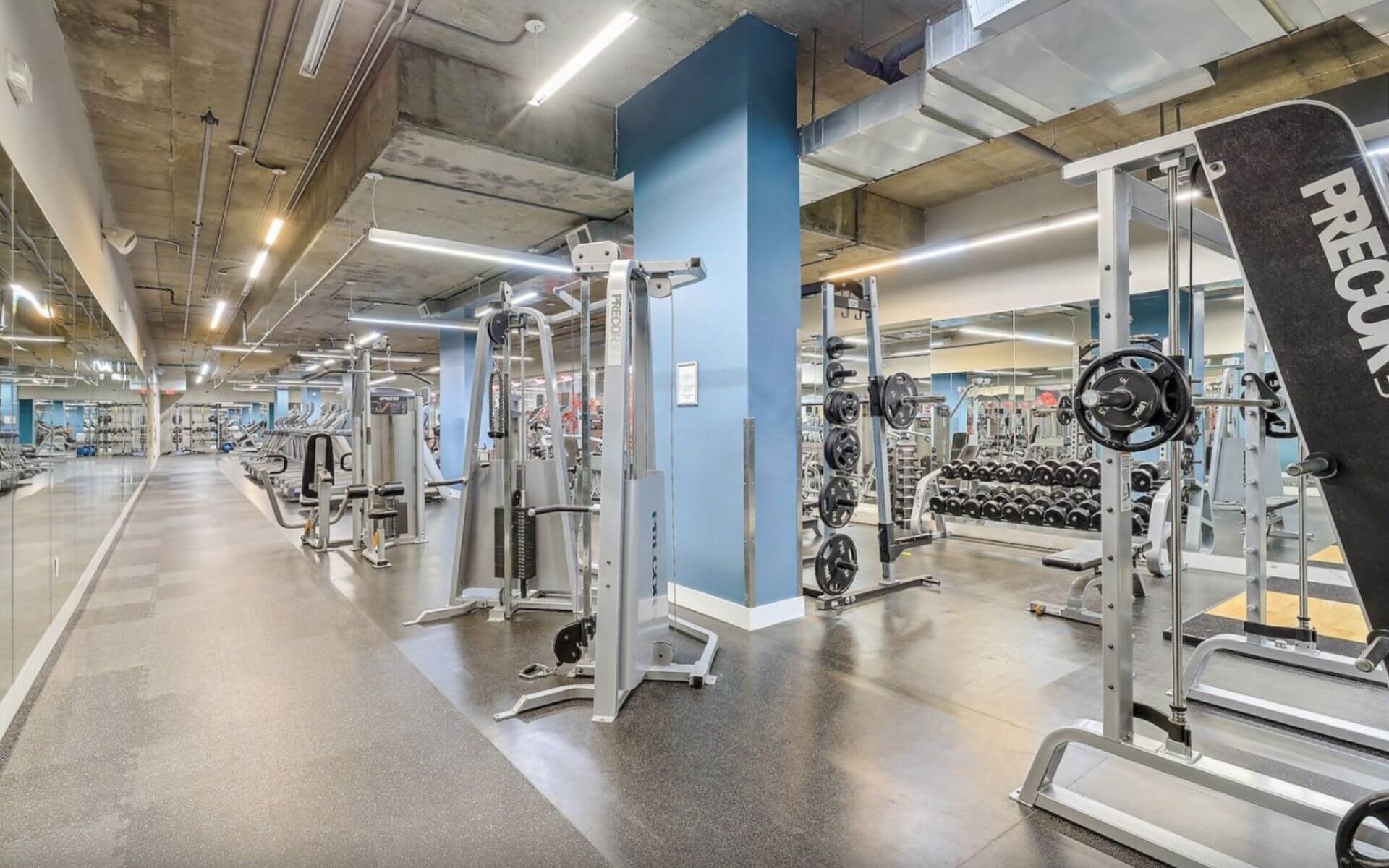 Fully equipped gym with modern machines and weights at 75 Tresser by Compass Furnished Apartments.
