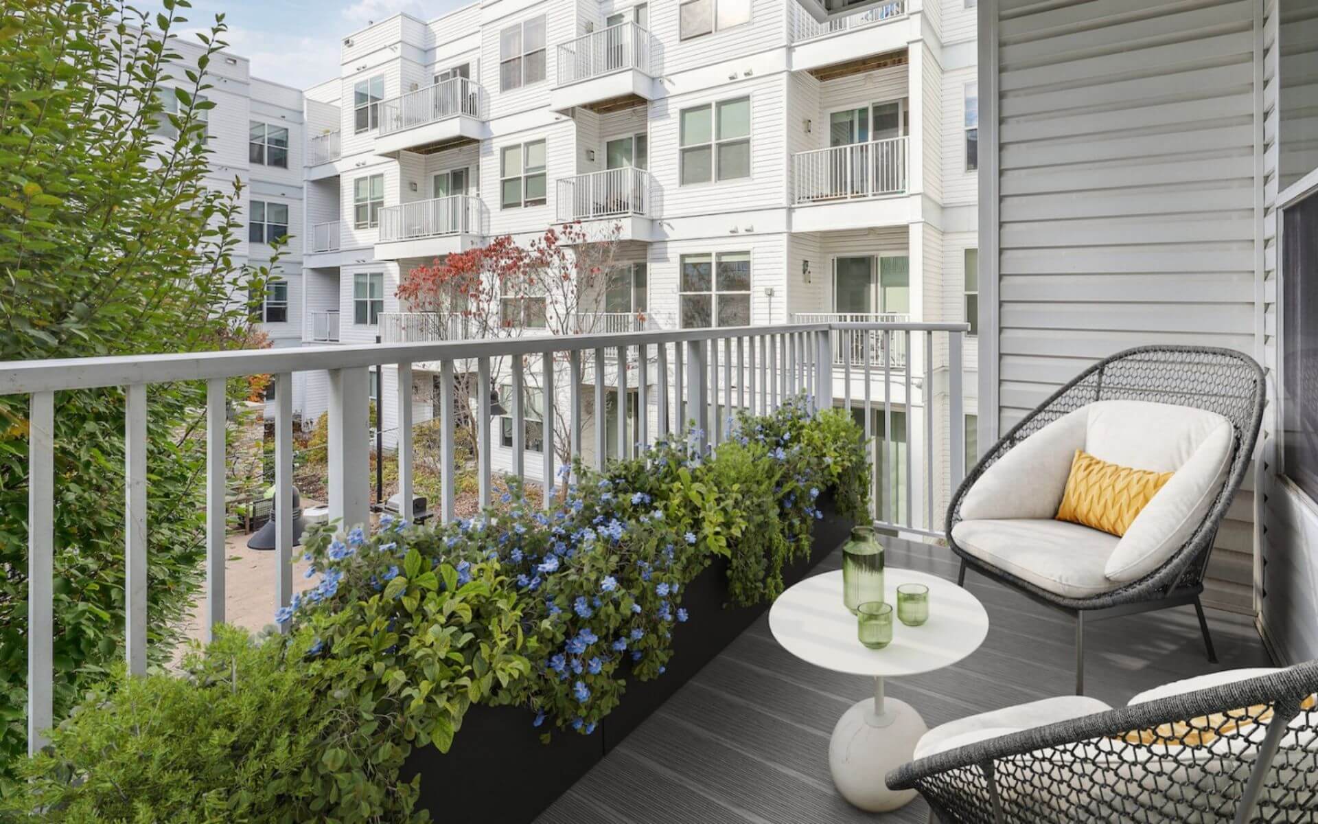 Private balcony with modern seating and garden views at 75 Tresser, a featured property from Compass Furnished Apartments.