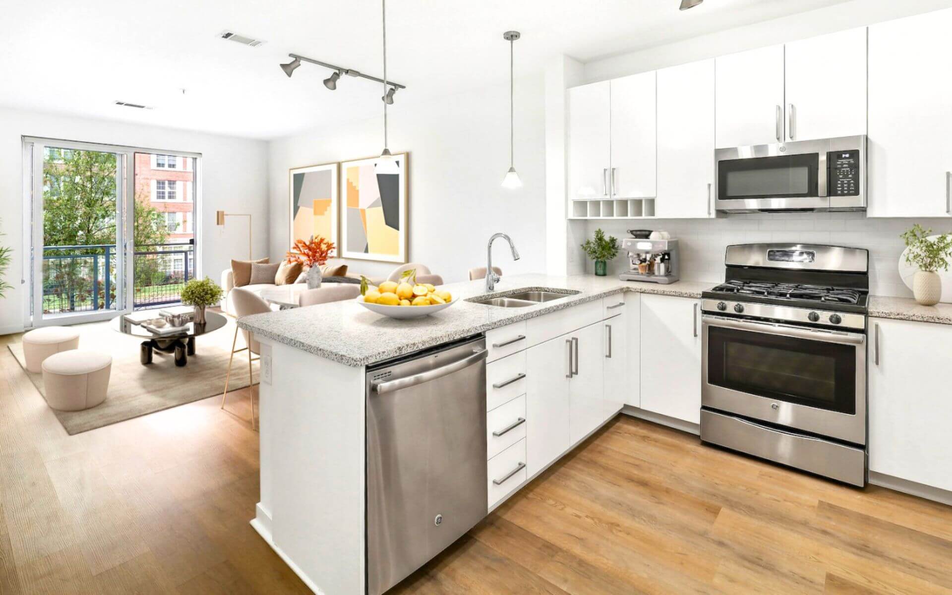 Bright kitchen and living area with stainless steel appliances and floor-to-ceiling windows at 75 Tresser, a Compass Furnished Apartments property.