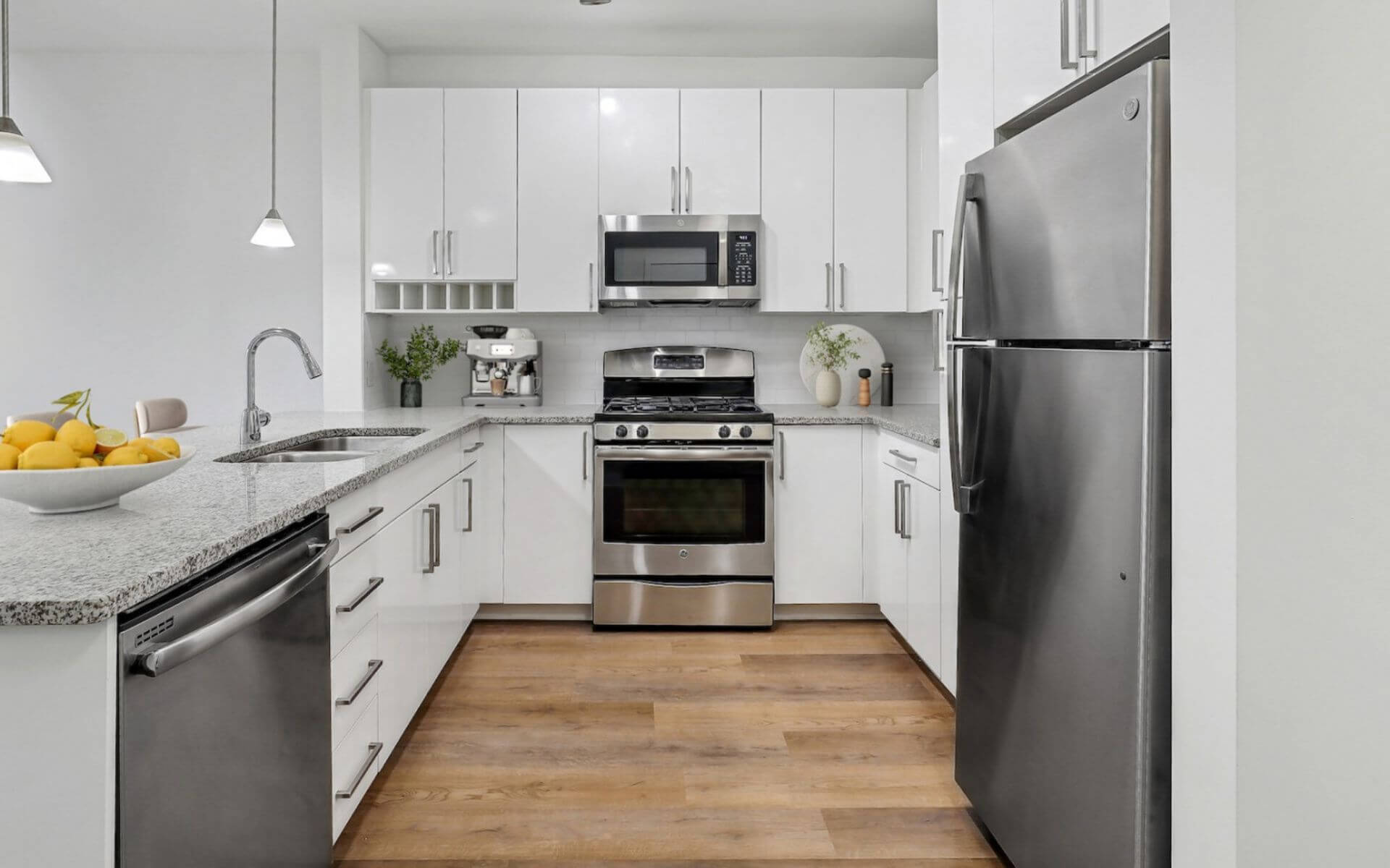 Sleek modern kitchen with stainless steel appliances and white cabinetry at 75 Tresser, a Compass Furnished Apartments location.