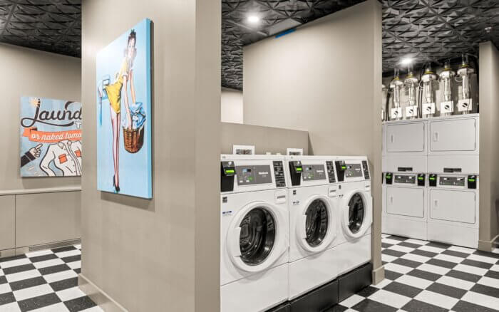 Well-equipped laundry room at The Revel by Compass Furnished Apartments