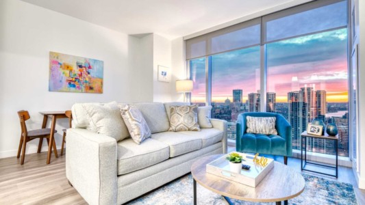 Hub50House Unit 2311 Living Room modern furnished living room in a business short-term rental apartment with a tv, kitchen, spacious work desk, and high-speed internet